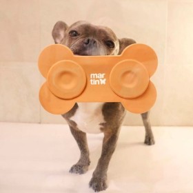 Tapis de léchage pour chien orange en silicone os MARTIN SELLIER fixé à la paroie de la douche pour occuper son chien