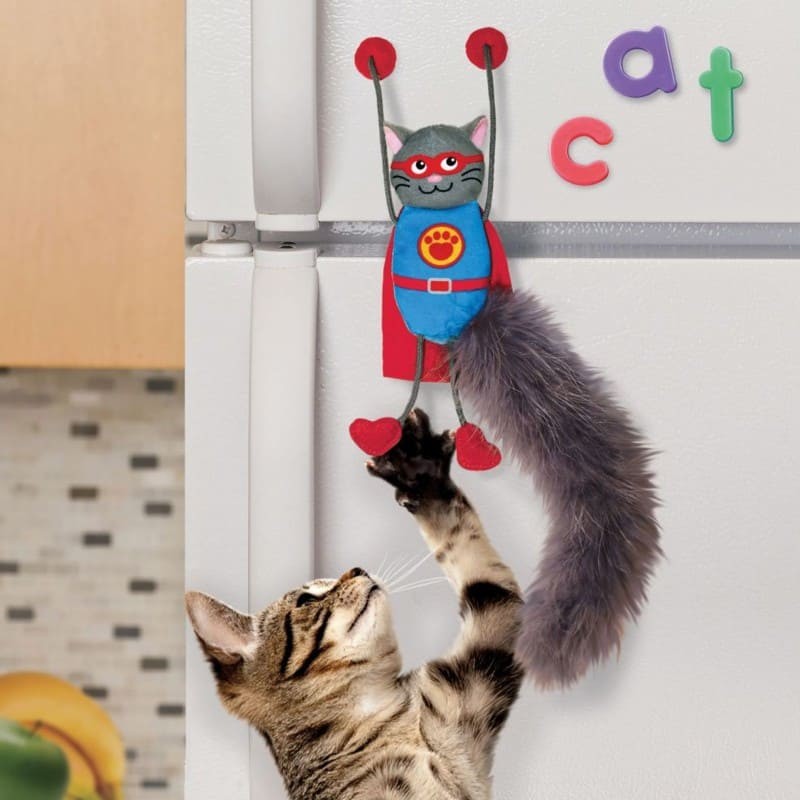 chat qui joue avec le jouet pour chat connects magnicat kong fixé sur le réfrigérateur