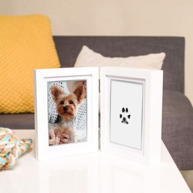 double cadre photo chien avec empreinte de patte en encre Pearhead posé sur une table basse