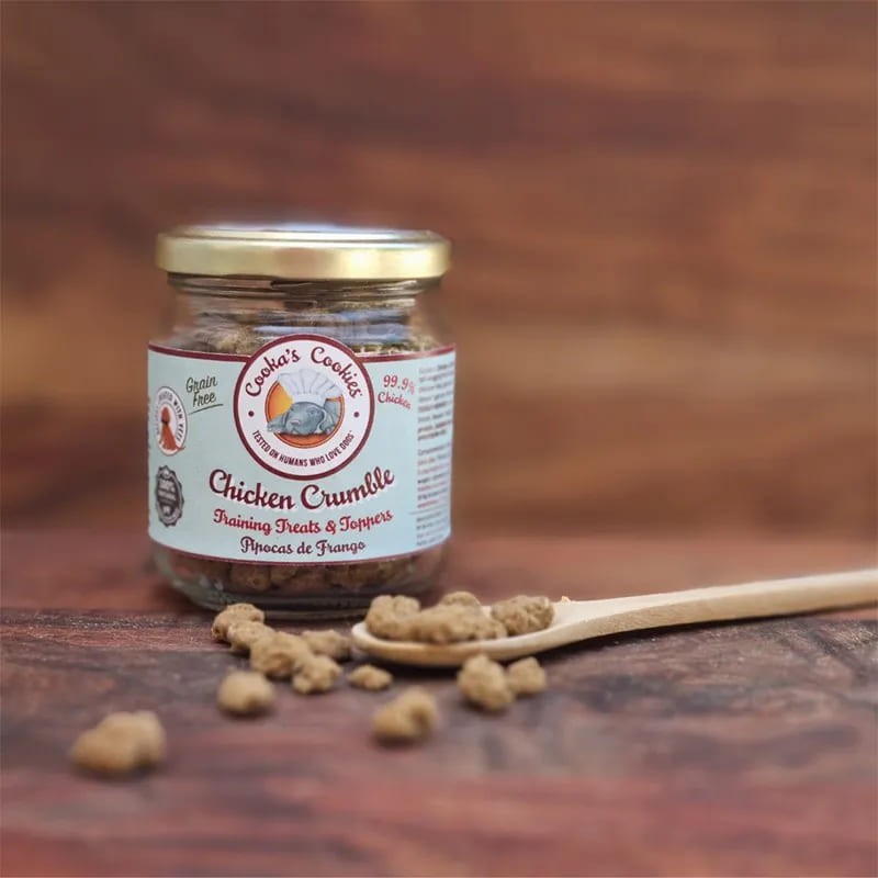 Booster de repas pour chien crumble de poulet Cooka's Cookies dans une cuillère avec le pot disposé à côté