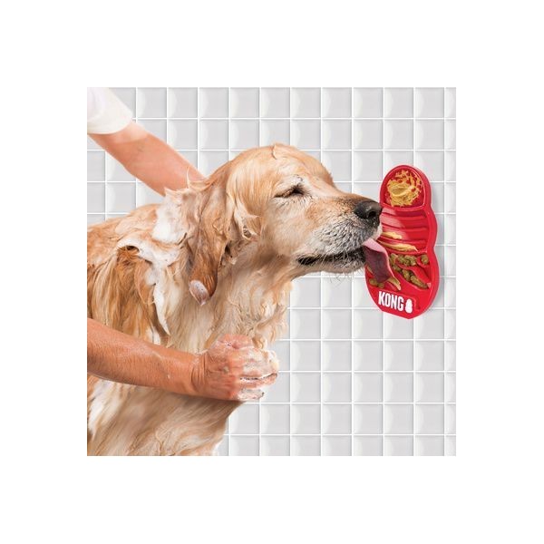 chien qui lèche le tapis de lechage kong pendant que son humaine le lave